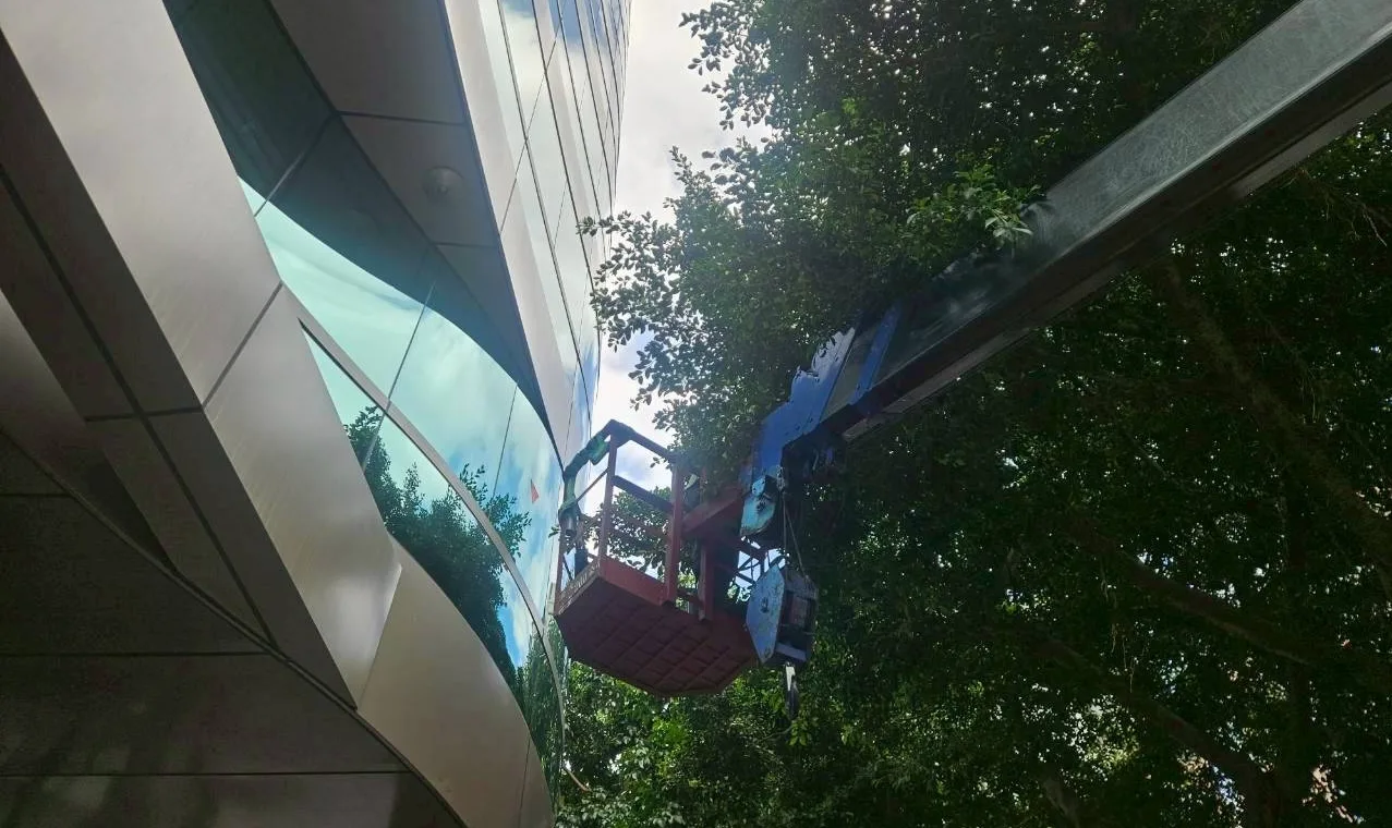 怡仁生態景觀高空作業車在台北市建築外牆旁精準作業,展示狹窄空間施工能力